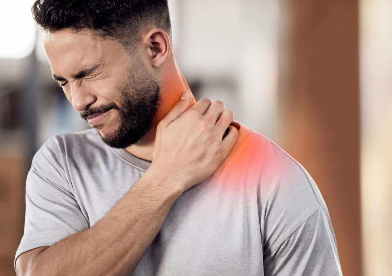 Man suffering discomfort in the neck and shoulder area requiring trapezius slimming injection treatment. 