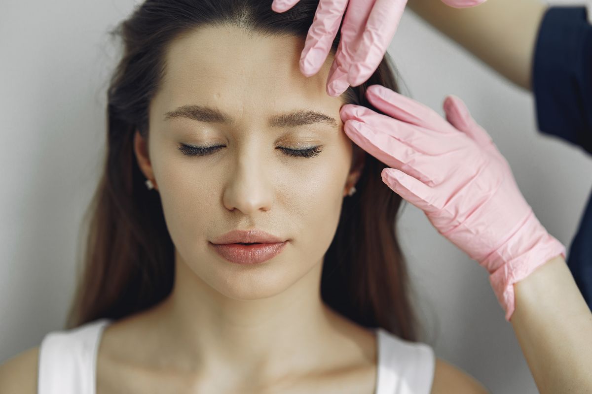 A cosmetic doctor examining a woman's face before treating wrinkles and fine lines