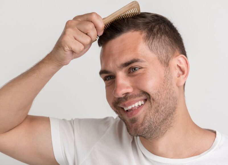 A happy man combing his full grown hair
