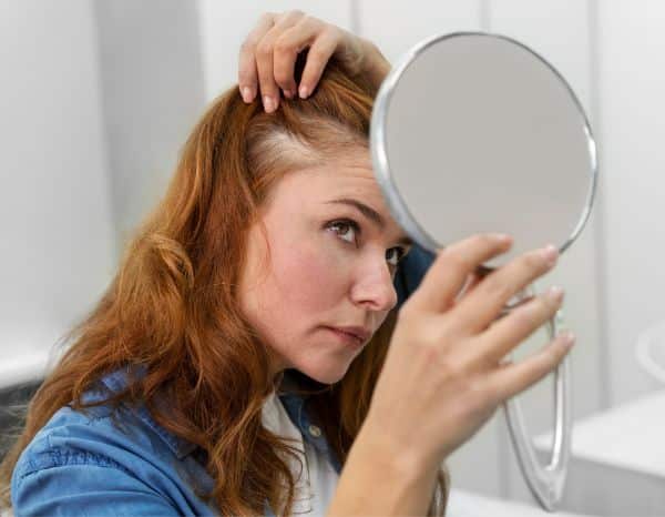 Woman checking her hair for any hair loss problems