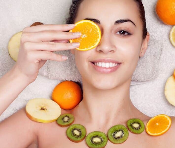young woman holding nutritious fruits for healthy skin